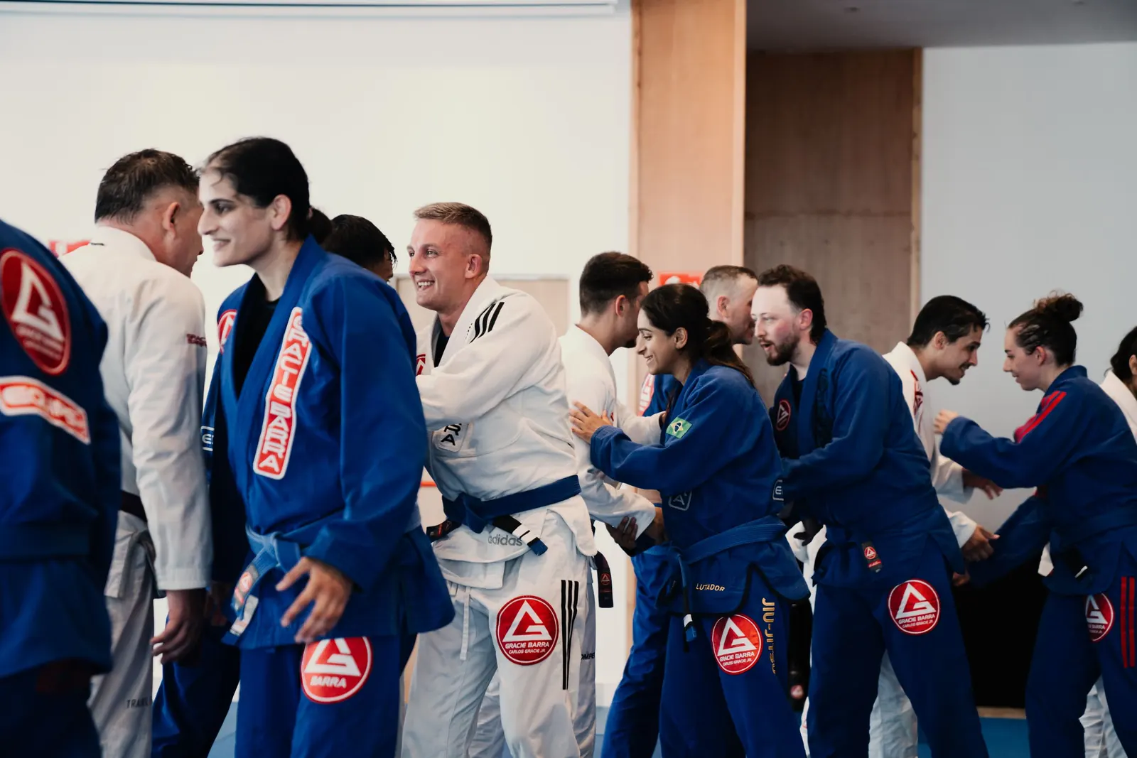 Students in blue and white gis congratulating each other after training
