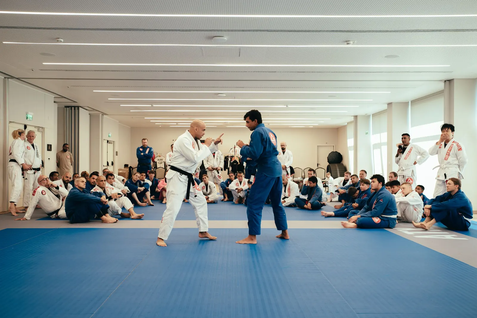A black belt coach demonstrating standing grips to a student