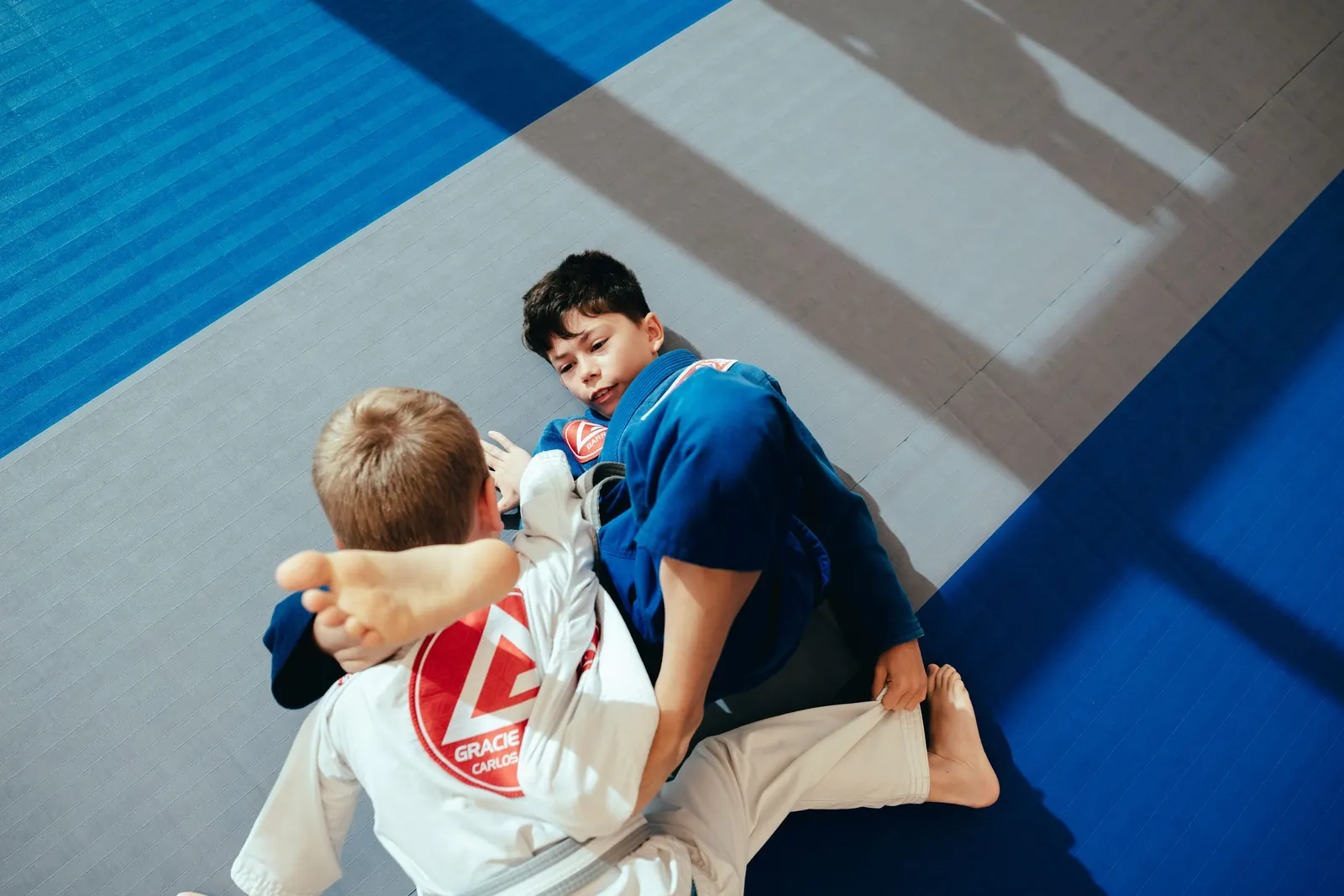 Two young students practising a safe grappling position