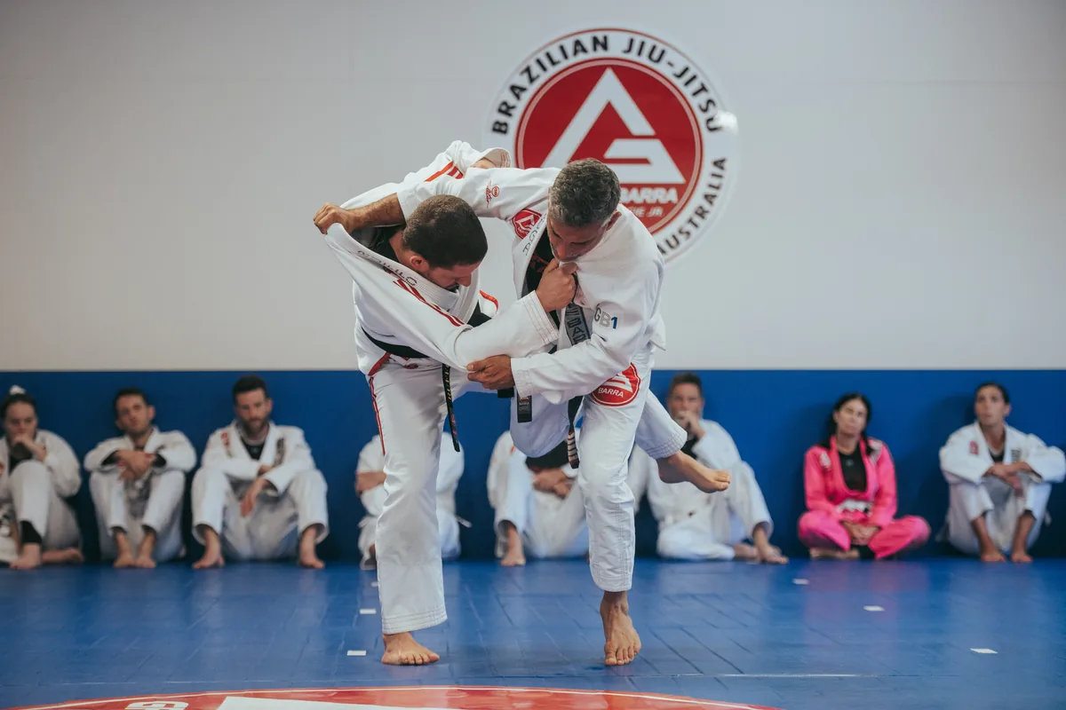 An instructor demonstrating a Jiu-Jitsu throw to students